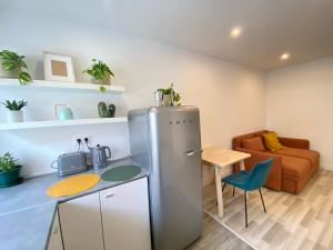 uma cozinha com um frigorífico, uma mesa e um sofá em Project Montalvão em Setúbal