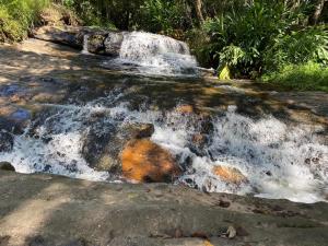 une cascade sur le côté d'une roche dans l'établissement Pousada Cachoeira Dos Sonhos, à Serra Negra