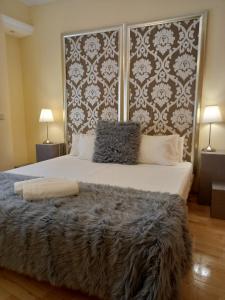 a bedroom with a large bed with a large headboard at Martin Gamero Apartments in Toledo