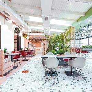un vestíbulo con mesas, sillas y plantas en Iliria Boutique Hotel, en Tirana