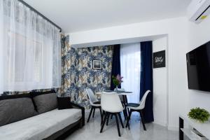 a living room with a couch and a table and chairs at Apartamenty Prestige in Łeba