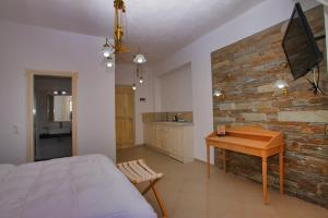 a bedroom with a bed and a wooden table at Mando Beachfront in Stafylos
