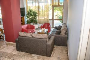 a living room with two couches and a table at Telis Hotel in Aigio