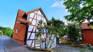 a small orange house with a fence around it at Zur Krone - Ferienhaus 3 in Widdershausen