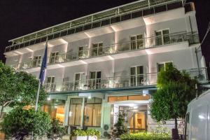 a white building with a balcony at night at Telis Hotel in Aigio