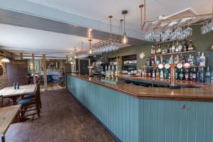 un bar dans un restaurant avec un mur bleu dans l'établissement Duke Of Marlborough, à Woodstock