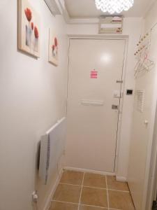 a hallway with a white door and a tiled floor at Stunning 1 bedroom apartment in Dagenham in Dagenham