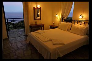 a bedroom with a bed with a view of the ocean at Mando Beachfront in Stafylos