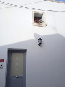 un bâtiment blanc avec une porte et une fenêtre avec une boîte de fleurs dans l'établissement La Corte dei Sogni, à Taviano