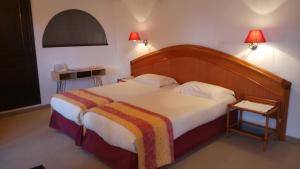 a bedroom with a large bed with a wooden headboard at Chambres d'hôtes Les Terrasses du Soleil in Cagnes-sur-Mer