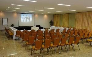 a conference room with a table and chairs and a screen at 701 - Flat Temporada em Goiania-proximo ao Parque Areião in Goiânia +19 photos