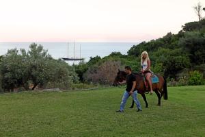 a man leading a woman on a horse in a field at Mando Beachfront in Stafylos