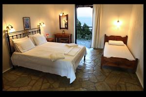 a bedroom with two beds and a balcony at Mando Beachfront in Stafylos