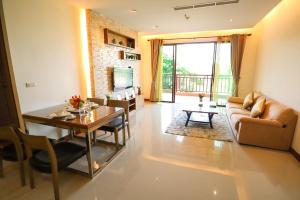 een woonkamer met een tafel en een bank bij Pattaya City Resort by Harmony in Pattaya