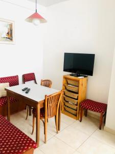 a dining room with a table and a tv at La Gare Apartment in Varna City