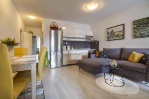 uma cozinha e sala de estar com um sofá e uma mesa em Apartman Seka em Njivice
