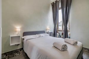 a bedroom with a large bed with towels on it at Roma House Piramide in Rome