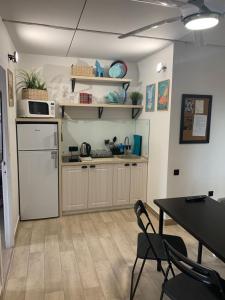 イジェフスクにあるGreen Park Apartmentのキッチン(白い冷蔵庫、テーブル、椅子付)
