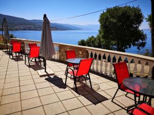 a patio with tables and chairs and an umbrella at Villa Kanata in Povile