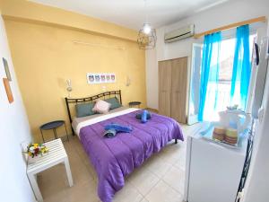 a bedroom with a purple bed in a room at Avra Budget Beach Rooms in Benitses