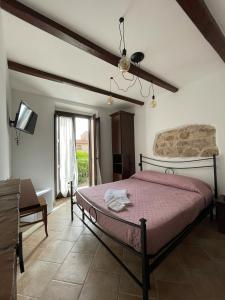 a bedroom with a bed and a tv in a room at La Vie En Rose in Fondi