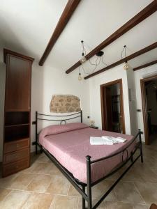 a bedroom with a bed with a pink comforter at La Vie En Rose in Fondi