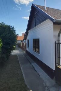 een wit gebouw met een raam aan de zijkant bij Feszty-fészek Vendégház in Tiszafüred