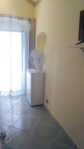 einen weißen Kühlschrank in einem Zimmer mit Fenster in der Unterkunft camera da loredana via marina centro storico in Peschici