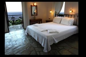 a bedroom with a bed with a view of the ocean at Mando Beachfront in Stafylos