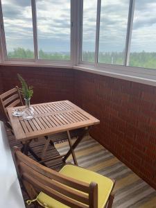 イジェフスクにあるGreen Park Apartmentの窓のある部屋(木製テーブル、椅子付)