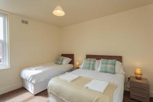 two twin beds in a room with a window at Cherry Property - Coconut Suite in Blackpool