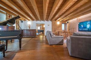 a living room with a piano and a couch at Au Berceau du Bien-Etre in Chambave