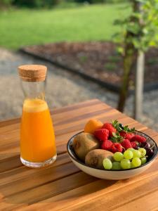 a plate of fruit and a bottle of orange juice at B&B Gusto in Halle