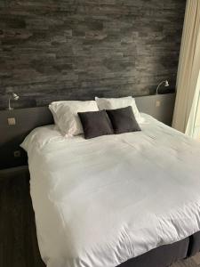 un grande letto bianco con due cuscini sopra di B&B Gusto a Halle
