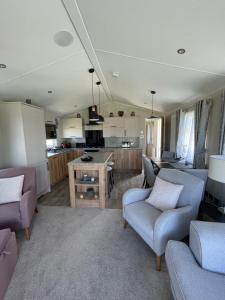 a living room with two couches and a kitchen at Seton sands holiday park - Premium caravan - 2 bedroom sleeps 4 in Port Seton