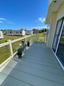 a porch of a house with a table and chairs at Seton sands holiday park - Premium caravan - 2 bedroom sleeps 4 in Port Seton