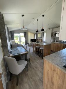 Seton sands holiday park - Premium caravan - 2 bedroom sleeps 4 في Port Seton: مطبخ مع طاولة وكراسي وكاونتر