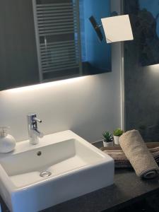 La salle de bains est pourvue d'un lavabo blanc et d'un miroir. dans l'établissement B&B Gusto, à Halle