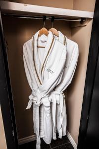 a group of white towels hanging in a closet at Old Stone Inn Boutique Hotel in Niagara Falls