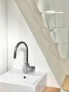 lavabo blanco en un baño con escalera en Boslucht Leuven, en Heverlee