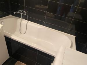 a white bath tub with a shower in a bathroom at Bay view apartment Mieszkanie z widokiem na zatoke in Sopot