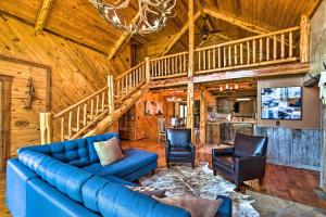 a living room with a blue couch and two chairs at Eureka Springs Area Cabin with Deck and 7 Acres! in Golden