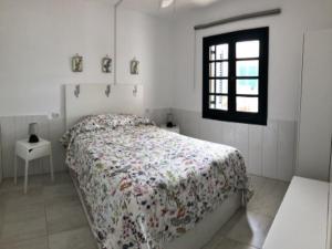 Una habitación blanca con una cama y una ventana en Puerta del Sol (Caleta de Fuste), en Caleta de Fuste