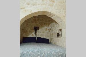 um quarto com uma cama numa parede de pedra em Trulli Monteforte em Villa Castelli