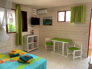 una habitación con una cama, una mesa y sillas en Les Lianes De Mysore, en Deshaies
