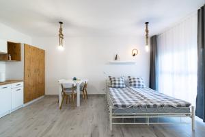 a bedroom with a bed and a table and a kitchen at Stella Marina in Sarbinowo