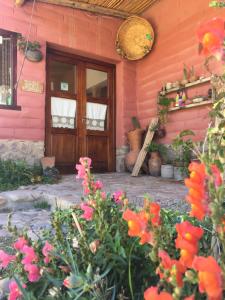 una puerta delantera de una casa rosa con flores en Hostería del Tantanakuy, en Humahuaca