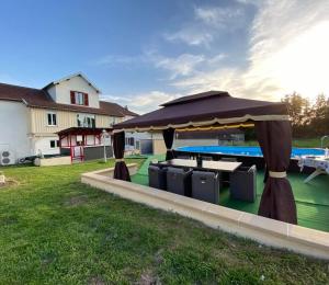 a large umbrella in a yard next to a pool at Maison de Campagne Sainte Barbe in Mirecourt