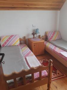 a room with two twin beds and a table at Kovcica Rooms in Žabljak