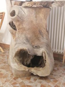 un gran tronco de árbol sentado en la parte superior de un piso en CASA DELLE GUARDIE b&b, en Madonna di Fornelli